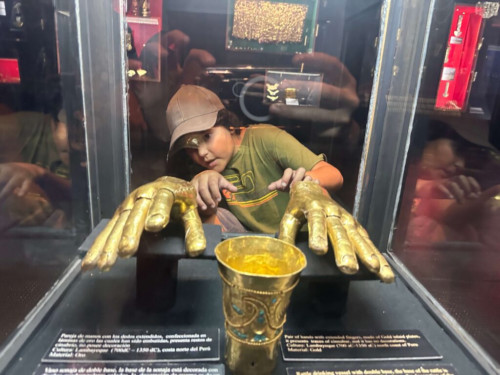boy admiring golden hands in gold museum