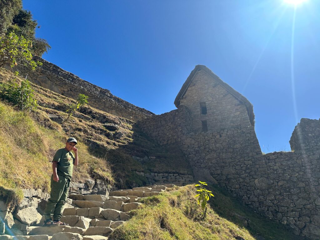 boy walking up stairs inside of Machu Picchu